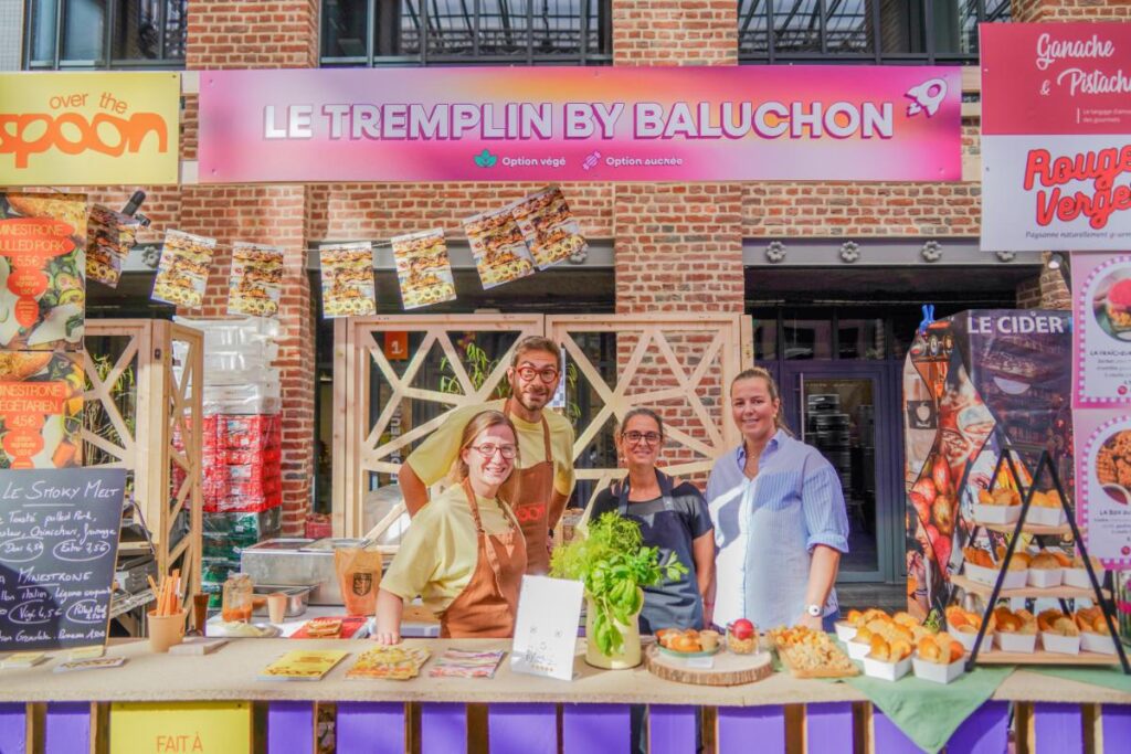 4 personnes posant derrière le stand "Le Tremplin By Baluchon" au Lille Street Food Festival 2025.